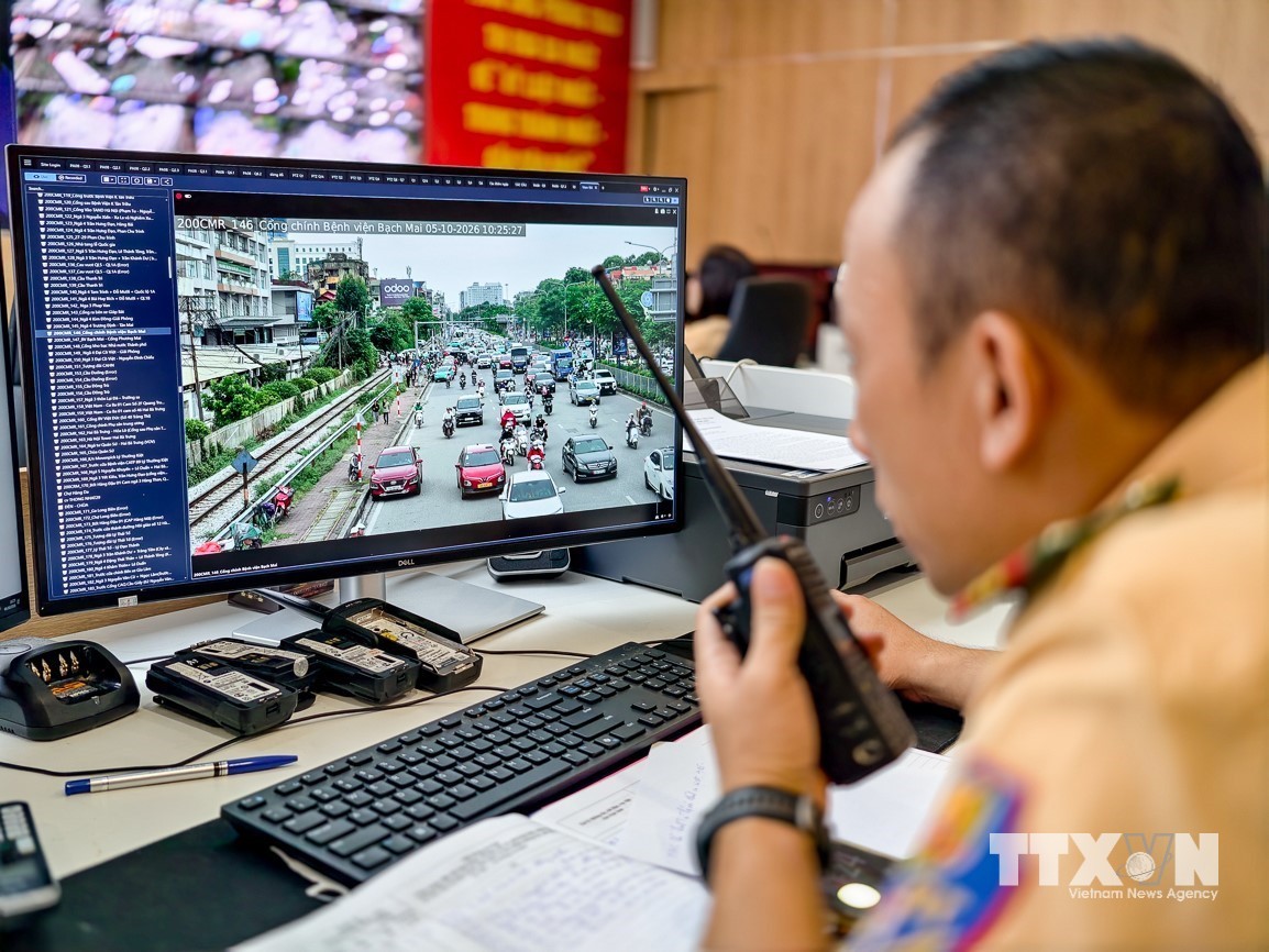 Cán bộ Đội Chỉ huy giao thông và điều khiển đèn tín hiệu giao thông theo dõi tình hình phương tiện qua hệ thống camera tại khu vực cầu Thanh Trì. (Ảnh: Trung Nguyên/TTXVN)